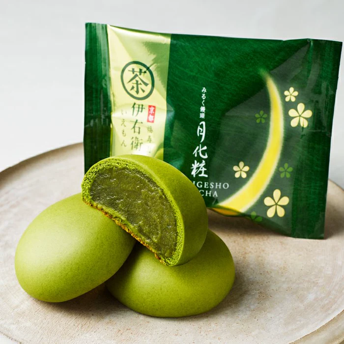 Tsukigesho matcha milk buns, one cut open, in front of the green wrapper (maker photo).